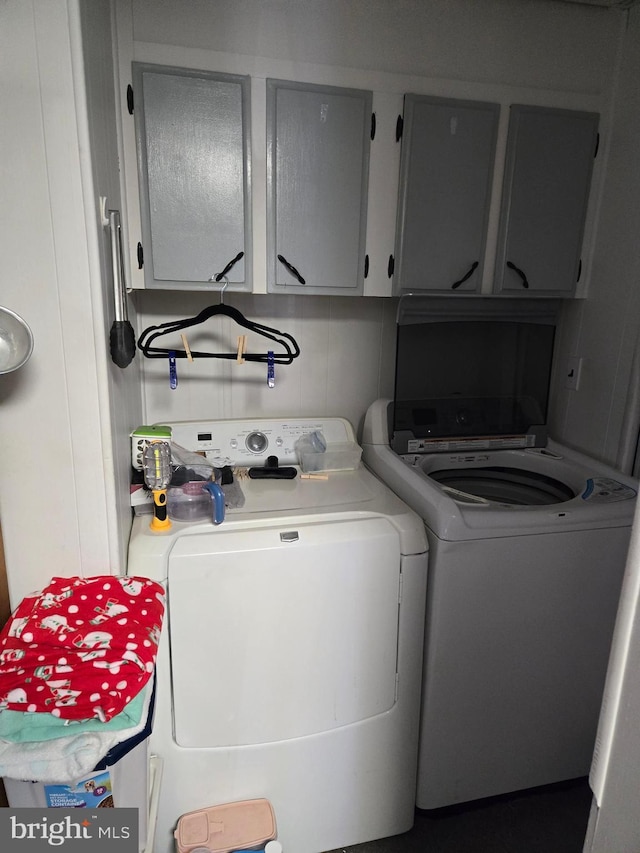 laundry area with washer and dryer and cabinets