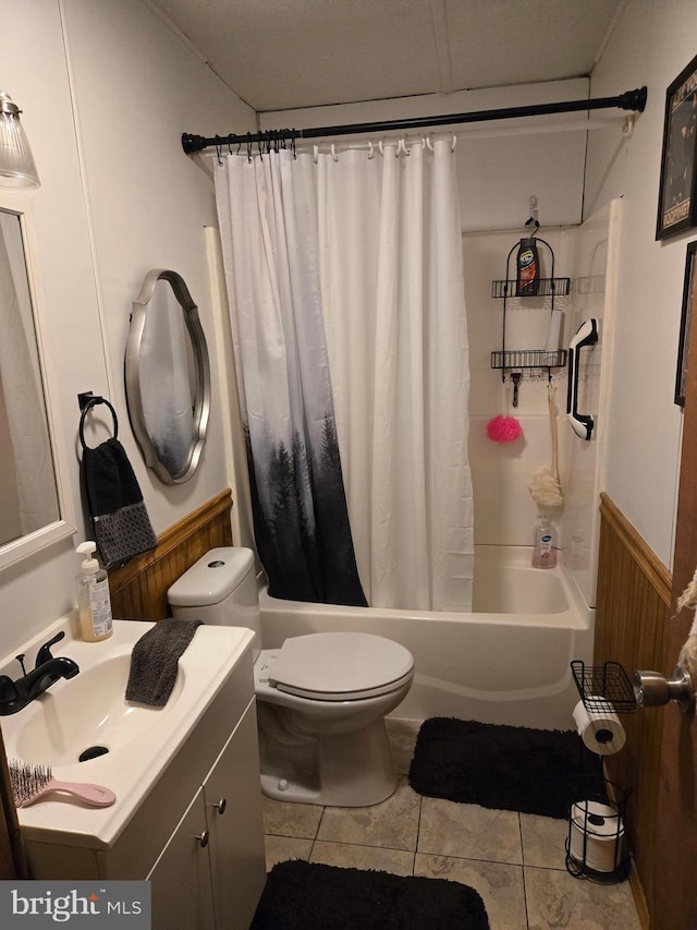 full bathroom featuring shower / bath combo, wood walls, vanity, tile patterned floors, and toilet