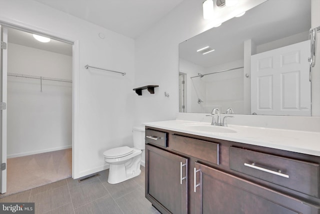 bathroom with a shower, vanity, and toilet