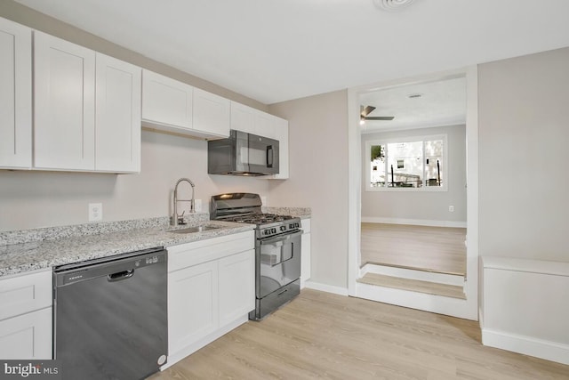 kitchen with black appliances, light hardwood / wood-style floors, white cabinetry, and sink