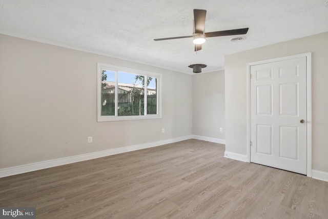 spare room with ceiling fan, light hardwood / wood-style flooring, and a textured ceiling