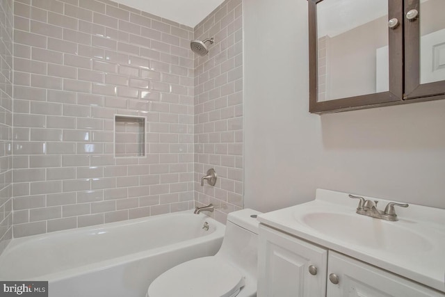 full bathroom with vanity, tiled shower / bath, and toilet