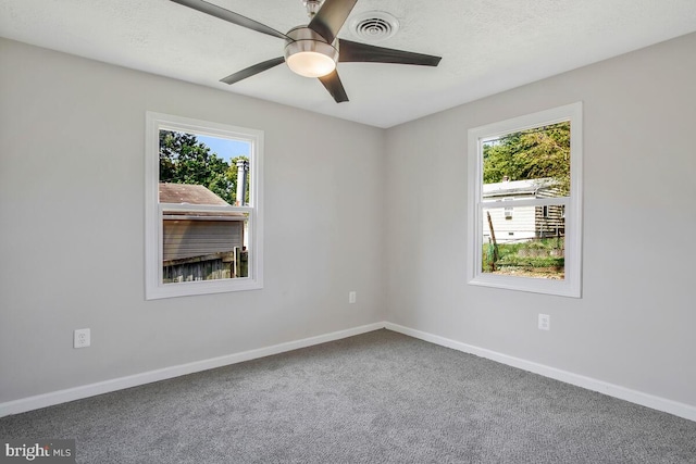 carpeted spare room featuring ceiling fan