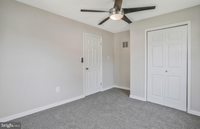 unfurnished bedroom with carpet flooring, ceiling fan, and a closet