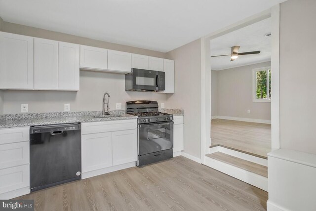 kitchen featuring black appliances, light hardwood / wood-style floors, white cabinets, and sink