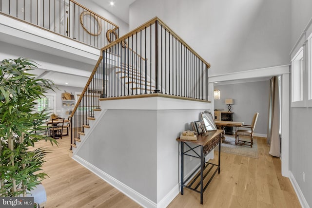 stairs featuring hardwood / wood-style floors and a high ceiling