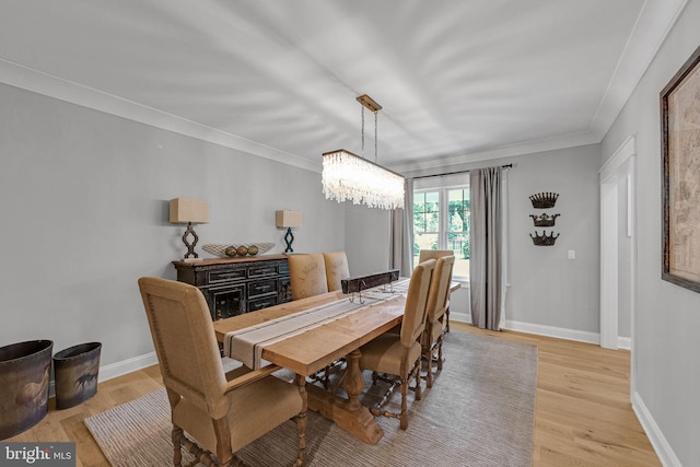 dining room with a chandelier, crown molding, and light hardwood / wood-style flooring