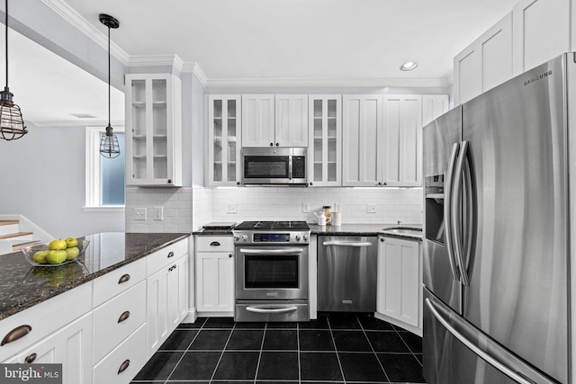 kitchen with appliances with stainless steel finishes, white cabinetry, and pendant lighting