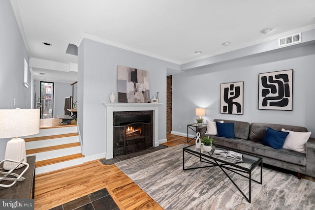 living room with wood-type flooring and ornamental molding