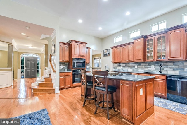 kitchen with tasteful backsplash, a center island, a breakfast bar area, and black appliances