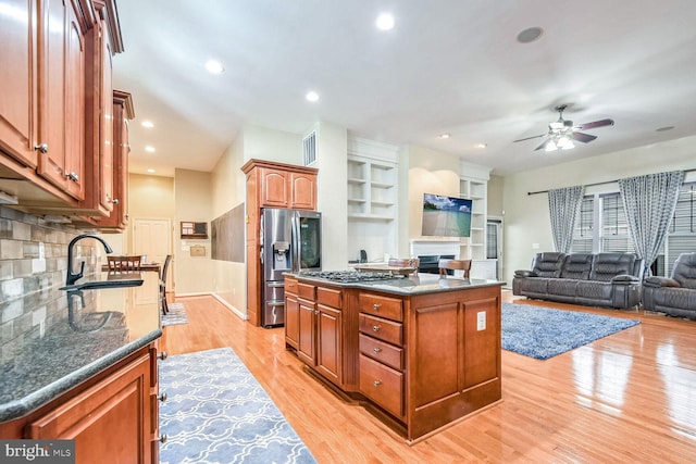 kitchen with a center island, sink, appliances with stainless steel finishes, and light hardwood / wood-style flooring