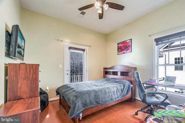 bedroom with hardwood / wood-style flooring, ceiling fan, and access to exterior