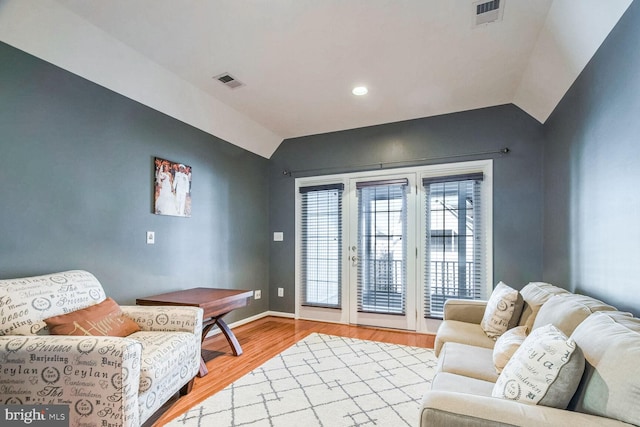 living area featuring wood-type flooring and vaulted ceiling