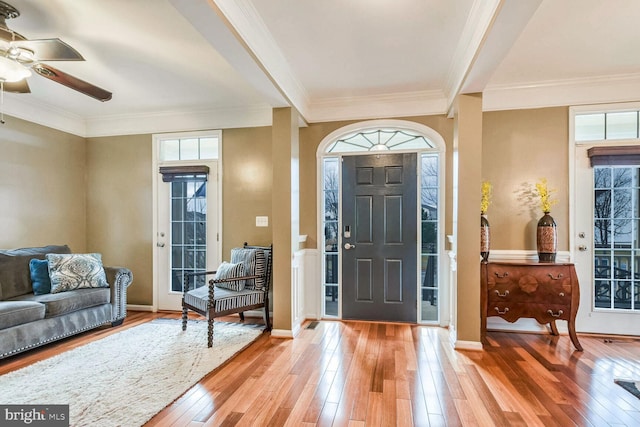 entryway with ceiling fan, wood-type flooring, and ornamental molding