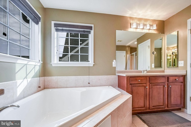 bathroom with tile patterned flooring, vanity, and independent shower and bath