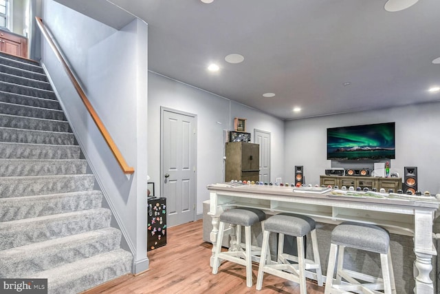 bar with light hardwood / wood-style floors