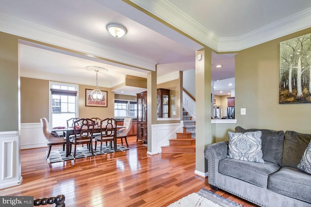 living room with wood-type flooring and ornamental molding