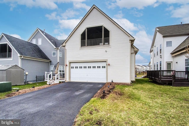 view of front facade featuring a front yard, a garage, a deck, and central air condition unit