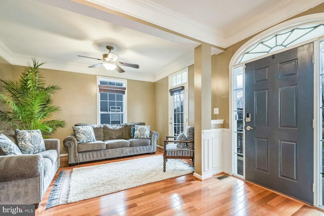 foyer entrance with ceiling fan, wood-type flooring, and crown molding