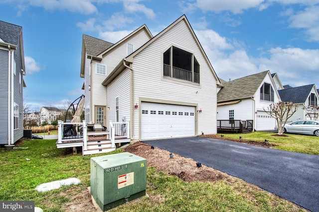 view of front of home with a front yard, a deck, and a garage