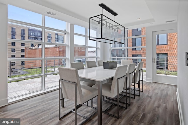 dining room with a fireplace, a notable chandelier, and hardwood / wood-style flooring