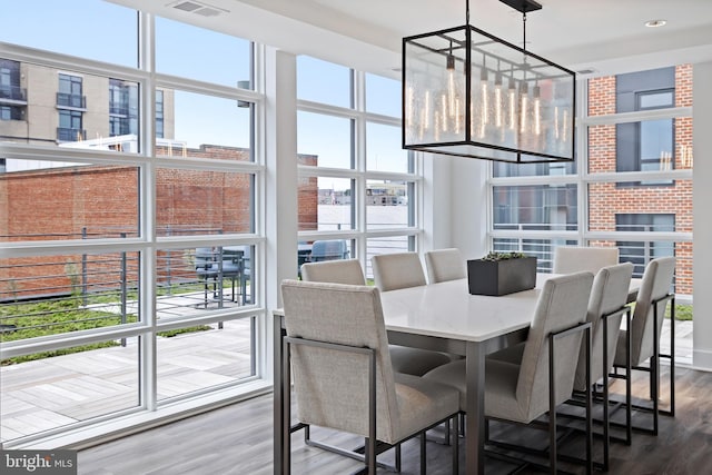 dining space with floor to ceiling windows and wood-type flooring