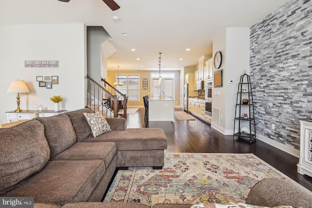 living room featuring ceiling fan and dark hardwood / wood-style flooring