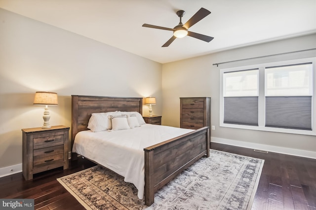 bedroom with ceiling fan, baseboards, and dark wood-style flooring