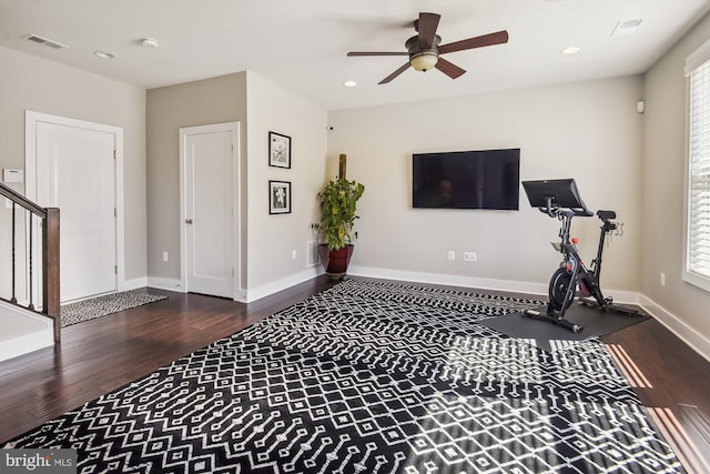 workout room featuring ceiling fan and dark wood-type flooring