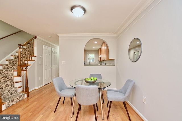 dining space with light hardwood / wood-style floors and ornamental molding