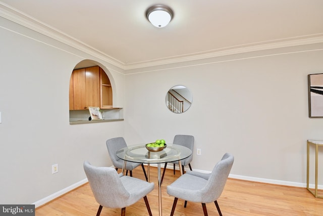 dining room featuring light wood-type flooring and ornamental molding