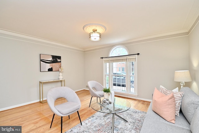 living area with wood-type flooring and ornamental molding