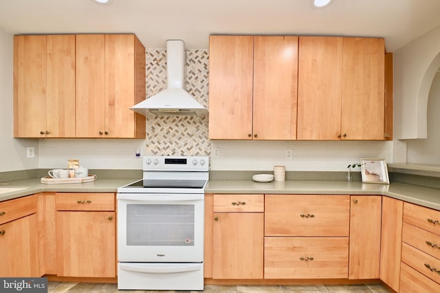 kitchen with light brown cabinetry, tasteful backsplash, white range with electric stovetop, and wall chimney exhaust hood