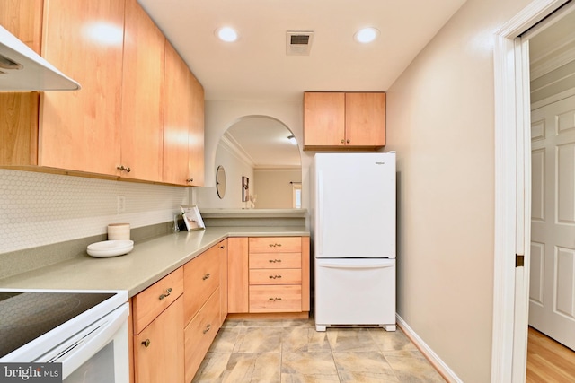 kitchen featuring tasteful backsplash, light brown cabinetry, white fridge, and exhaust hood