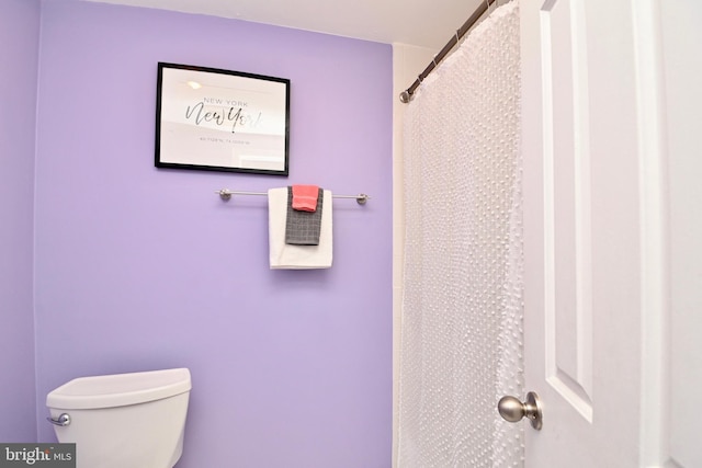 bathroom featuring a shower with shower curtain and toilet