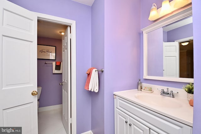 bathroom with tile patterned flooring, vanity, and toilet