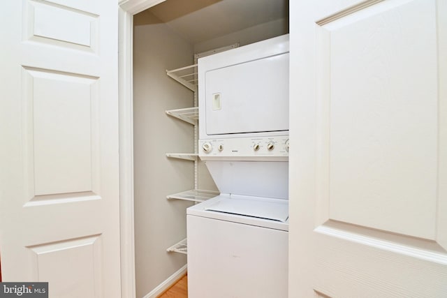 clothes washing area featuring stacked washer and dryer