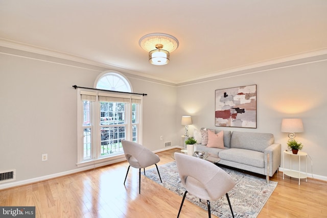 living room featuring light wood-type flooring and ornamental molding