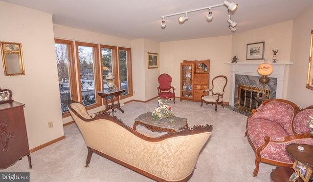 living room with light carpet, a fireplace, and rail lighting