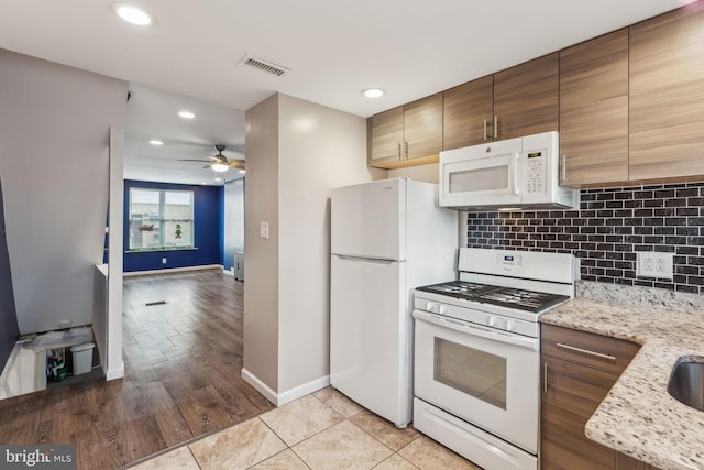 kitchen with light stone countertops, tasteful backsplash, white appliances, ceiling fan, and light tile patterned flooring