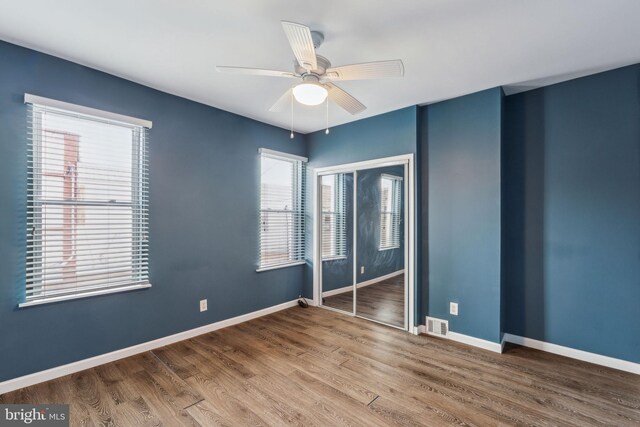 unfurnished bedroom featuring ceiling fan, a closet, and wood-type flooring