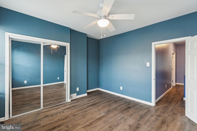 unfurnished bedroom featuring ceiling fan, dark wood-type flooring, and a closet