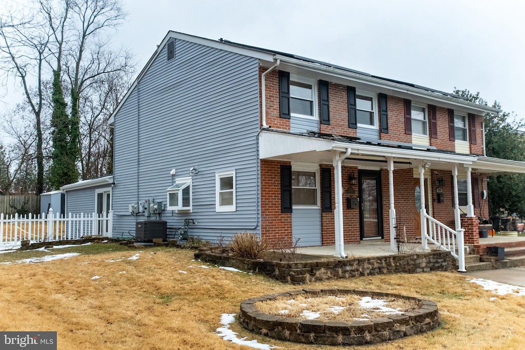 view of front of property with a front lawn and central AC