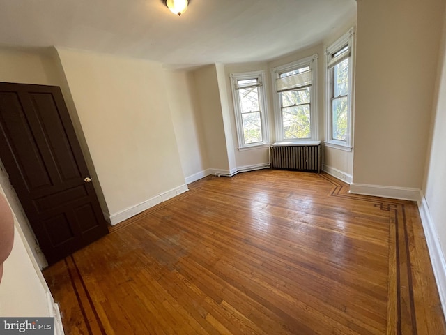 unfurnished room featuring radiator and wood-type flooring