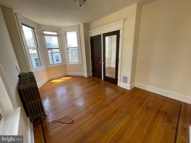 empty room with hardwood / wood-style floors and radiator