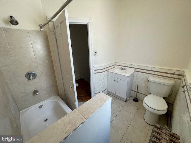 full bathroom featuring tile patterned floors, vanity, tile walls, toilet, and tiled shower / bath