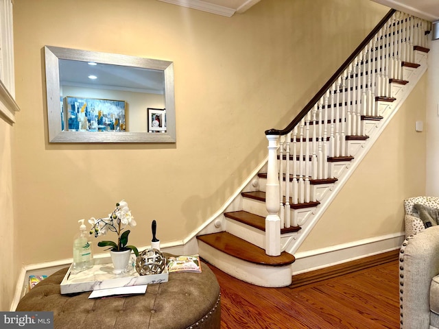 stairway featuring hardwood / wood-style flooring and ornamental molding