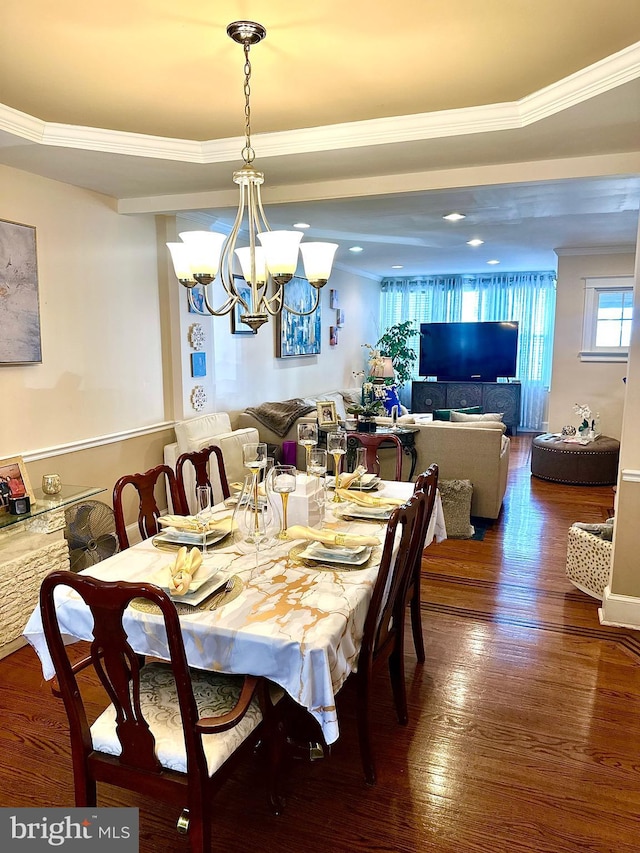 dining area with dark wood-type flooring, crown molding, and a notable chandelier