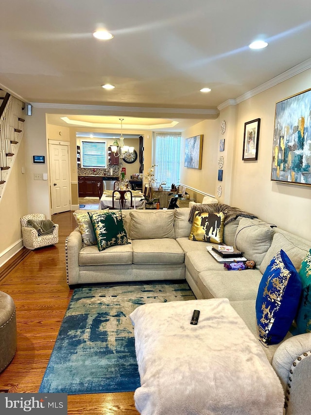 living room with a chandelier, dark hardwood / wood-style floors, and ornamental molding