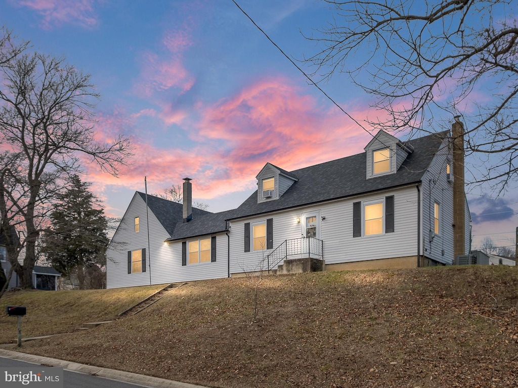 cape cod home with a lawn